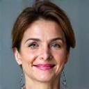 Portrait of Dr. Elena Petrova, a Caucasian woman with kind eyes and a professional demeanor, smiling gently.